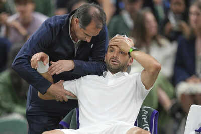 Grigor Dimitrov receives medical attention during his match against Jannik Sinner at Wimbledon 2025.