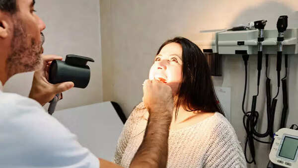 Doctor examining patient's mouth for oral cancer during a checkup